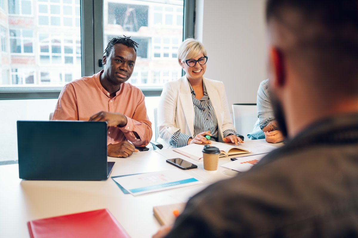A multiracial business team discussing leadership development in a modern office meeting